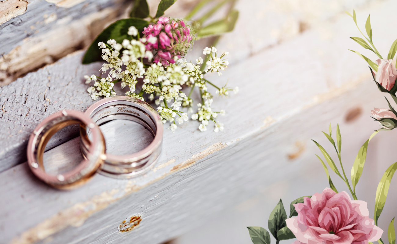 alliance de mariage posées sur une table avec des fleurs